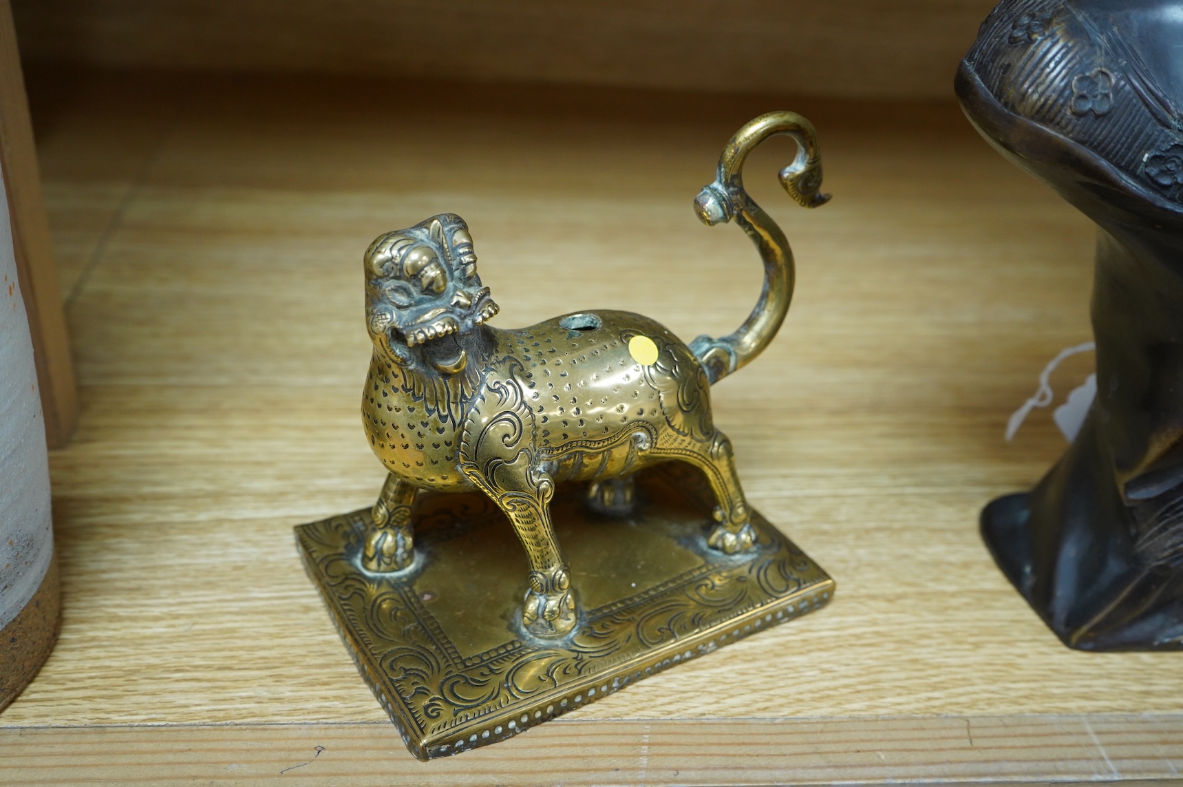 A 19th century south-east Asian brass incense holder in the form of a lion, 12cm wide